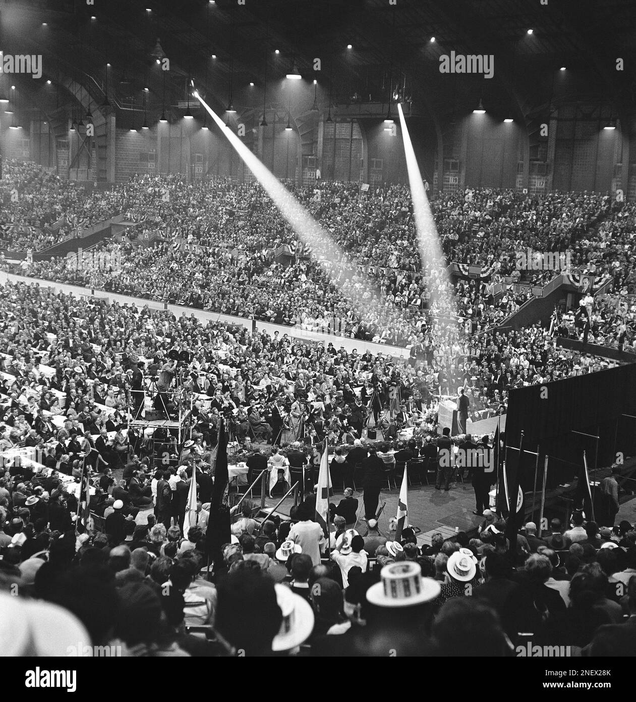 Sen. John Kennedy, standing in the cross of spotlights, speaks to a full house at the Indiana State Fairgrounds coliseum, Oct. 4, 1960 in Indianapolis, Indiana. Kennedy is on a two day tour of Indiana cities in his bid for the presidency. (AP Photo/Larry Stoddard) Foto Stock