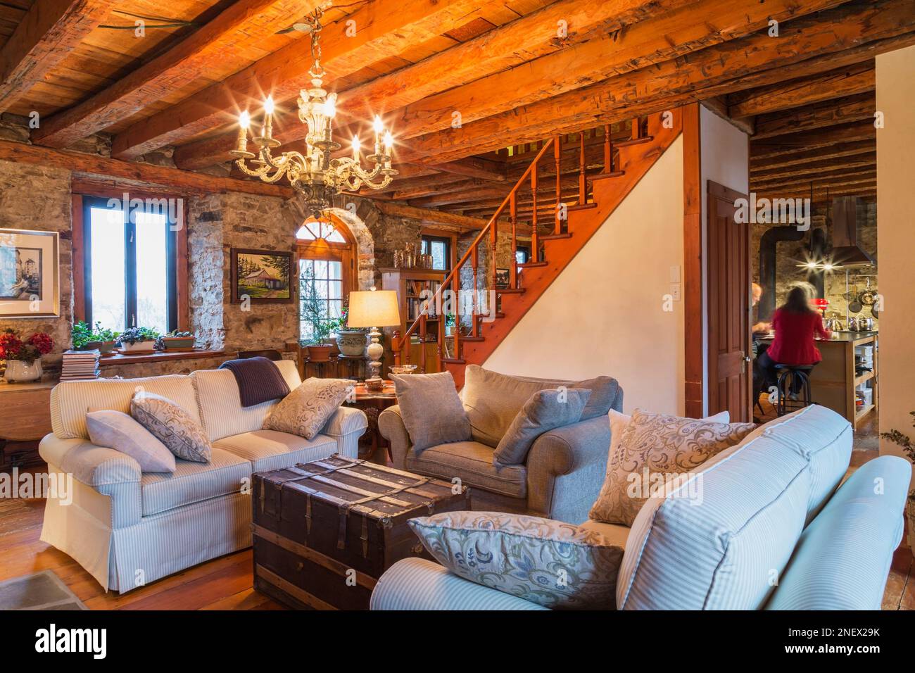 Amorini rivestiti in grigio e beige e antico tavolo sul torace nel soggiorno con pavimenti in legno di pino all'interno di una vecchia casa in stile cottage del 1820. Foto Stock