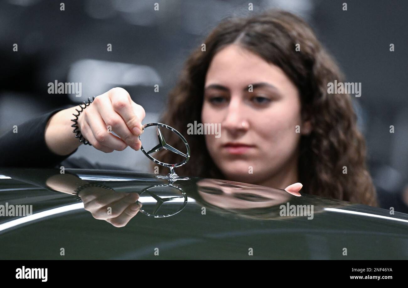 Sindelfingen, Germania. 13th Feb, 2023. Un dipendente del produttore di automobili Mercedes-Benz di Stoccarda lavora su un cofano motore su un emblema Mercedes nella fabbrica 56 dello stabilimento Merecdes-Benz di Sindelfingen, Germania, nella produzione di automobili di lusso e di lusso. Oltre all'EQS, tutte le varianti della Mercedes-Benz S-Class e della Mercedes-Maybach S-Class escono dalla linea di produzione presso lo stabilimento 56. Venerdì la società presenterà i dati finanziari del 2022. Credit: Bernd Weißbrod/dpa/Alamy Live News Foto Stock