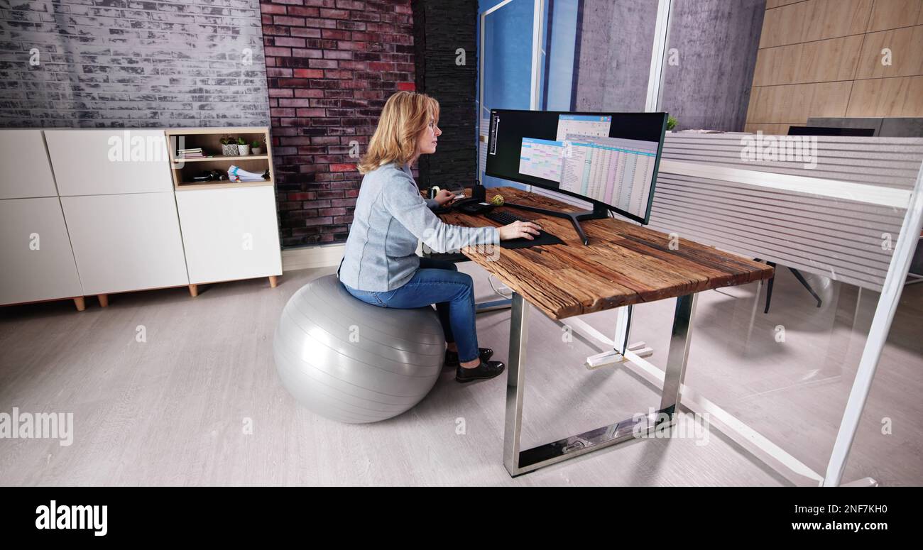 Correggere la postura alla scrivania in ufficio usando la sfera di idoneità Foto Stock