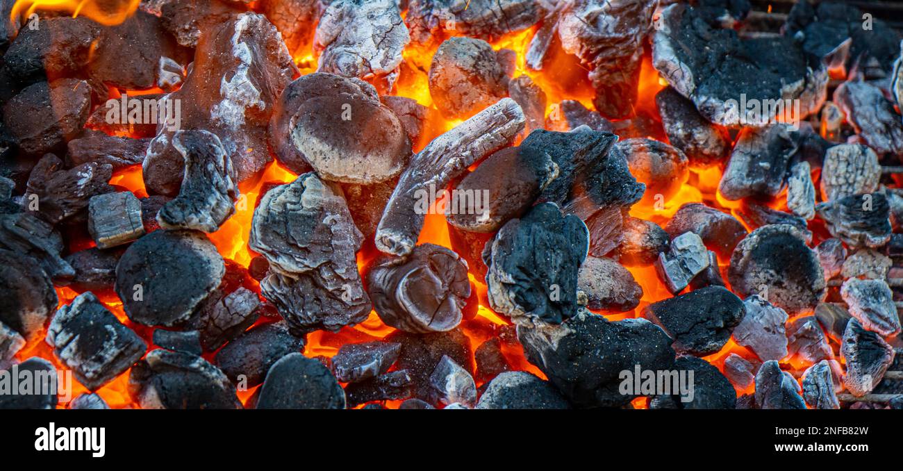Carbone e brace che brucia a piena capacità al suo picco in un barbecue di metallo Foto Stock