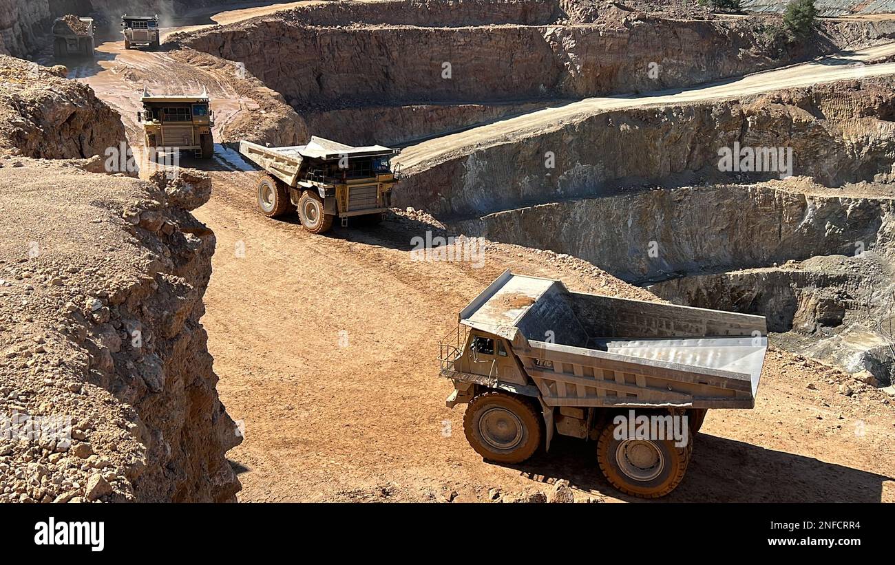 Lavorando in un enorme sito minerario, i dumper trasportano il materiale. Foto Stock