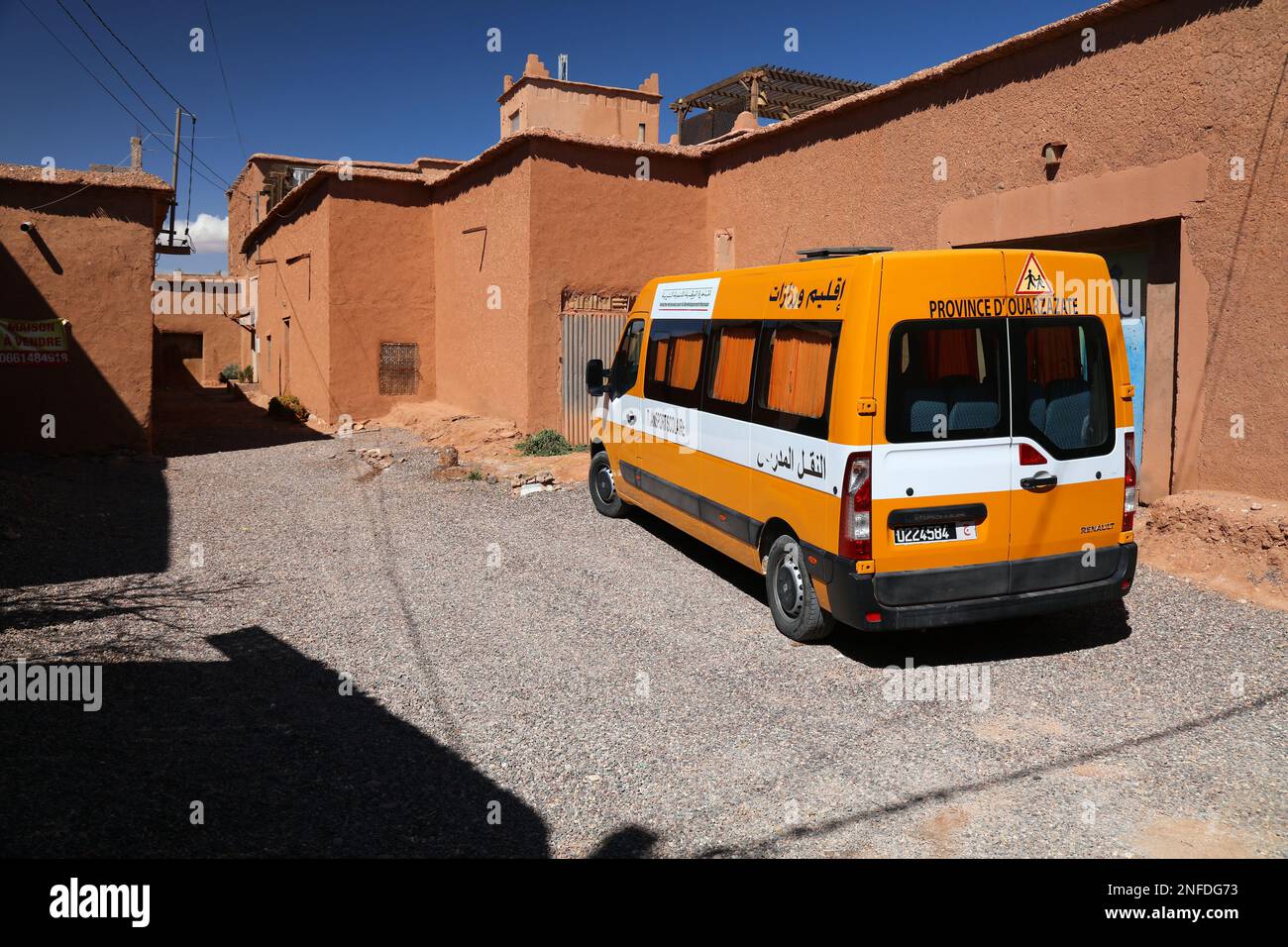 OUARZAZATE, MAROCCO - 19 FEBBRAIO 2022: Autobus scuola gialla parcheggiato in Marocco rurale. È stato finanziato dalla National Human Development Initiative (INDH). Foto Stock
