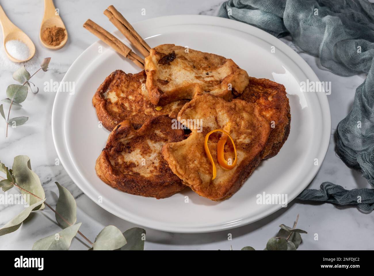 Set di torrija su un piano di marmo. Dolce tipico spagnolo fatto di pane, latte, uova, zucchero e cannella, consumato durante il Carnevale e Pasqua Foto Stock