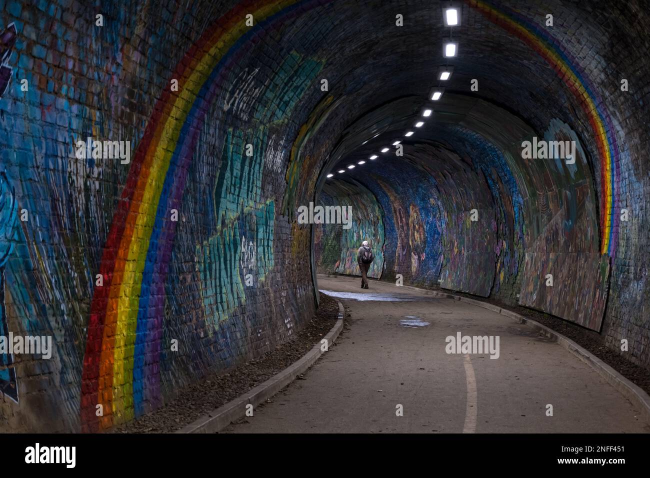 Uomo che cammina nel tunnel ferroviario di Colinton dipinto dall'artista Chris Rutterford, Edimburgo, Scozia, Regno Unito Foto Stock