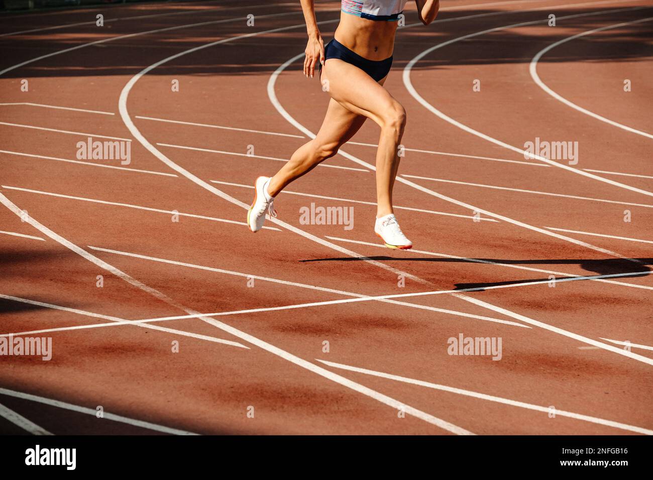 atleta femminile che corre in pista Foto Stock