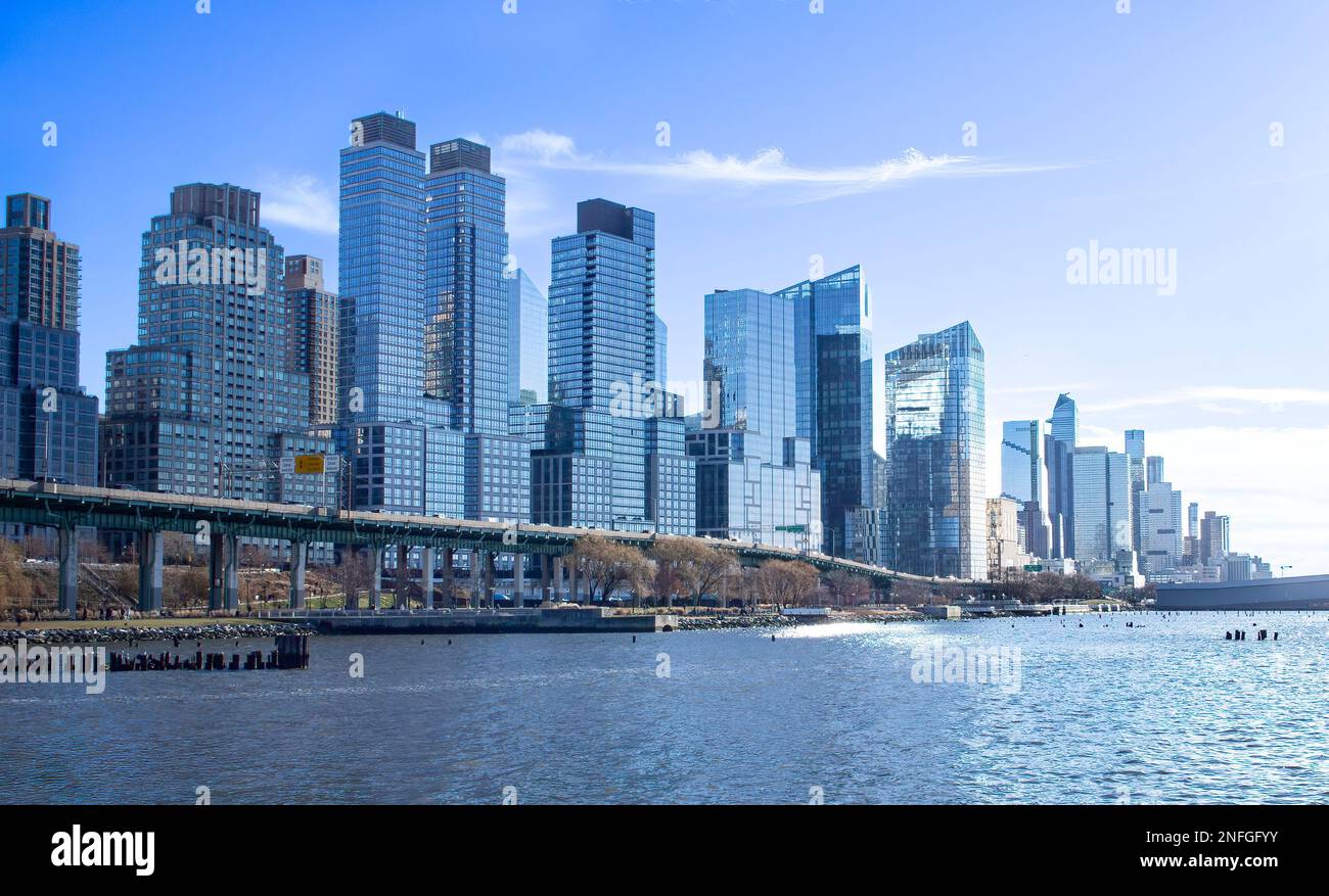 Grattacieli, edifici lungo la Henry Hudson Parkway e la West Side Highway, Manhattan, New York City, in una soleggiata giornata invernale. Fiume Hudson in primo piano. Foto Stock