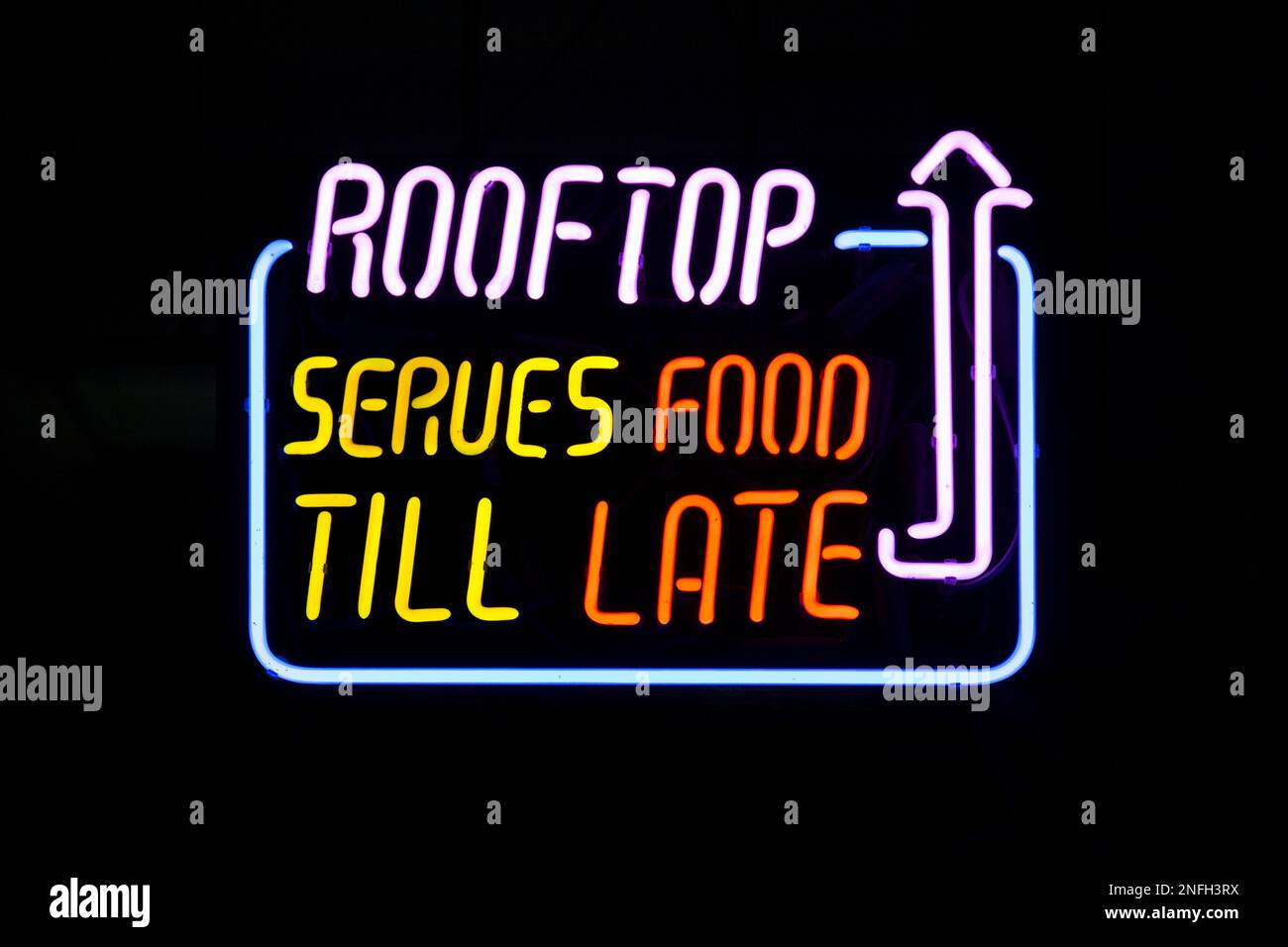 Luce al neon rettangolare con una freccia che indica un ristorante che dice Rooftop serve cibo fino a tardi. Foto Stock