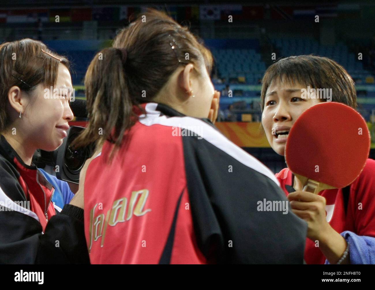 Japan's Sayaka Hirano, right, comes back to her teammates Haruna Fukuoka, left, and Ai Fukuhara, center, after Hirano's victory over Hong Kong's Tie Yana in her match during their women's table tennis team play-off round at the Beijing 2008 Olympics in Beijing, Saturday, Aug. 16, 2008. Japan beat Hong Kong. (AP Photo/Chitose Suzuki) Foto Stock