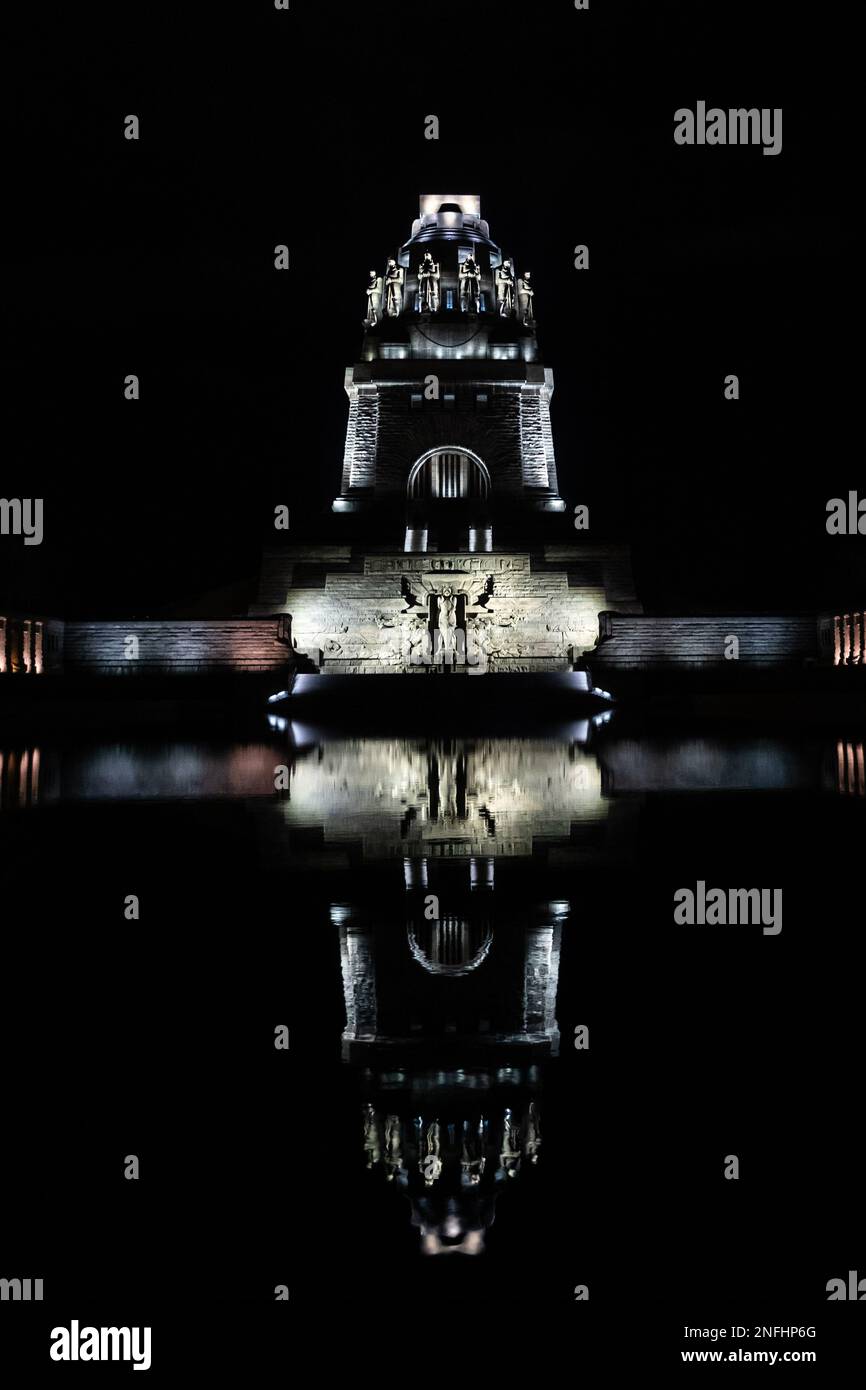 Foto notturna del Monumento alla Battaglia delle Nazioni 1813 a Lipsia, riflessione in acqua, ripresa verticale, punto di riferimento e commemorazione Foto Stock