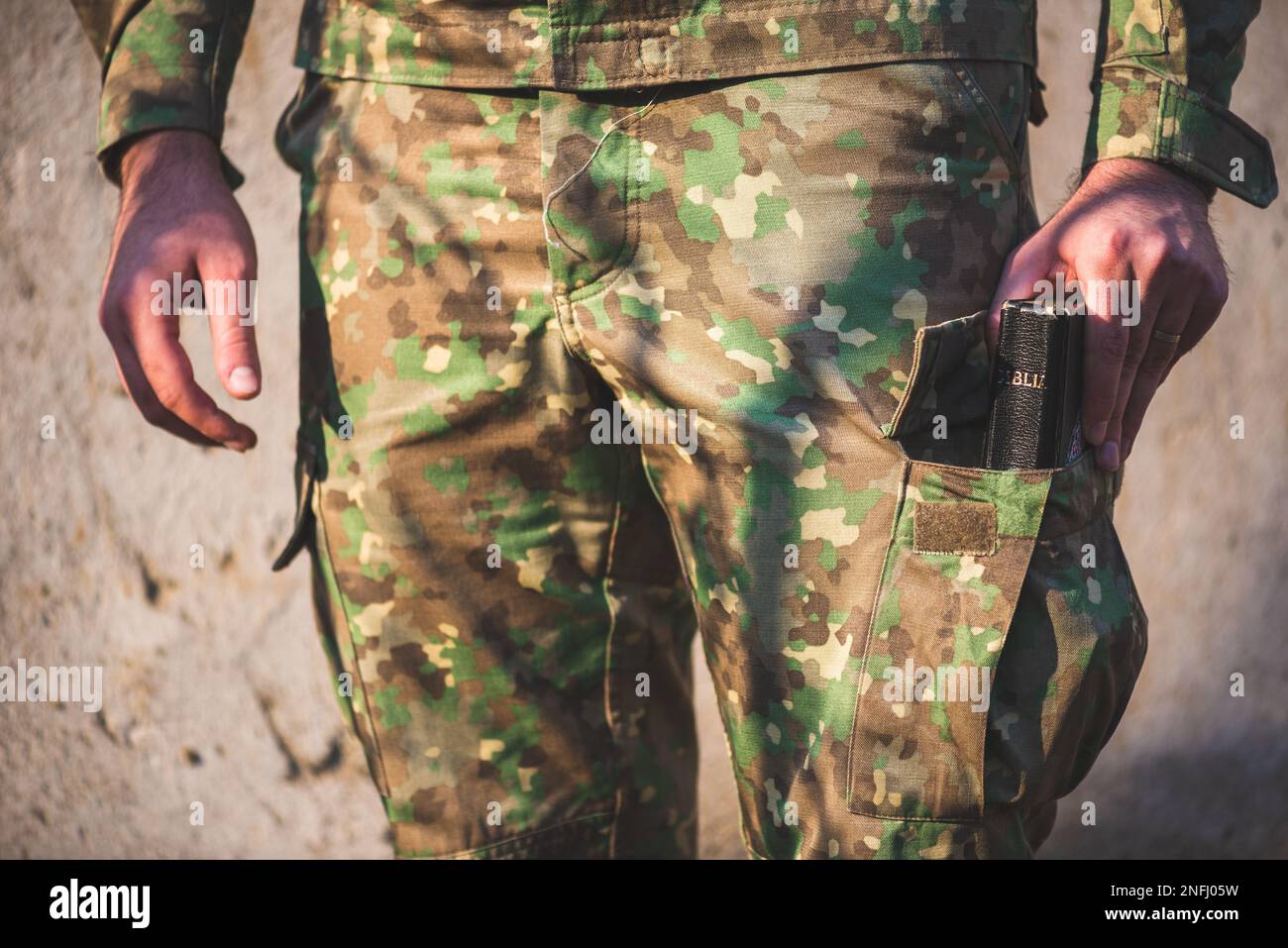 Soldato vestito in uniforme mimetizzata con una bibbia nella tasca dei piedi Foto Stock