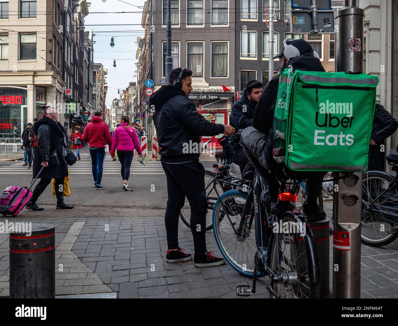 Amsterdam, Paesi Bassi. 15th Feb, 2023. Un gruppo di lavoratori DI UBER si vede parlare mentre si fa una pausa per la strada. Amsterdam è una delle città più belle, creative e ciclabili d'Europa. Ha un ottimo mix di atmosfera cosmopolita e dimensioni relativamente piccole, il che significa che ha un fascino simile a quello di un villaggio. Anche se è ancora freddo ma soleggiato, i turisti stanno già visitando la capitale olandese nei giorni feriali. I luoghi più visitati sono di solito piazza Dam, il centro della città, i musei e i canali. (Foto di Ana Fernandez/SOPA Images/Sipa USA) Credit: Sipa USA/Alamy Live News Foto Stock