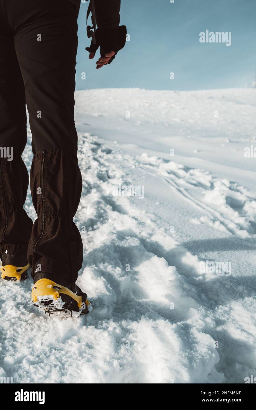 Primo piano di un uomo che si arrampica su una montagna coperta di neve, in  scarponi con le punte delle scarpe. Trekking invernale all'aperto Foto  stock - Alamy