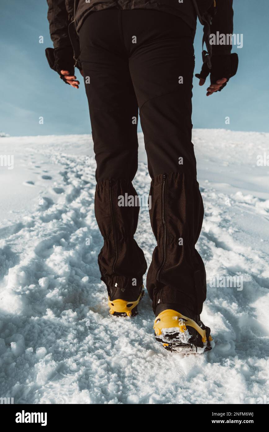 Primo piano di un uomo che si arrampica su una montagna coperta di neve, in  scarponi con le punte delle scarpe. Trekking invernale all'aperto Foto  stock - Alamy