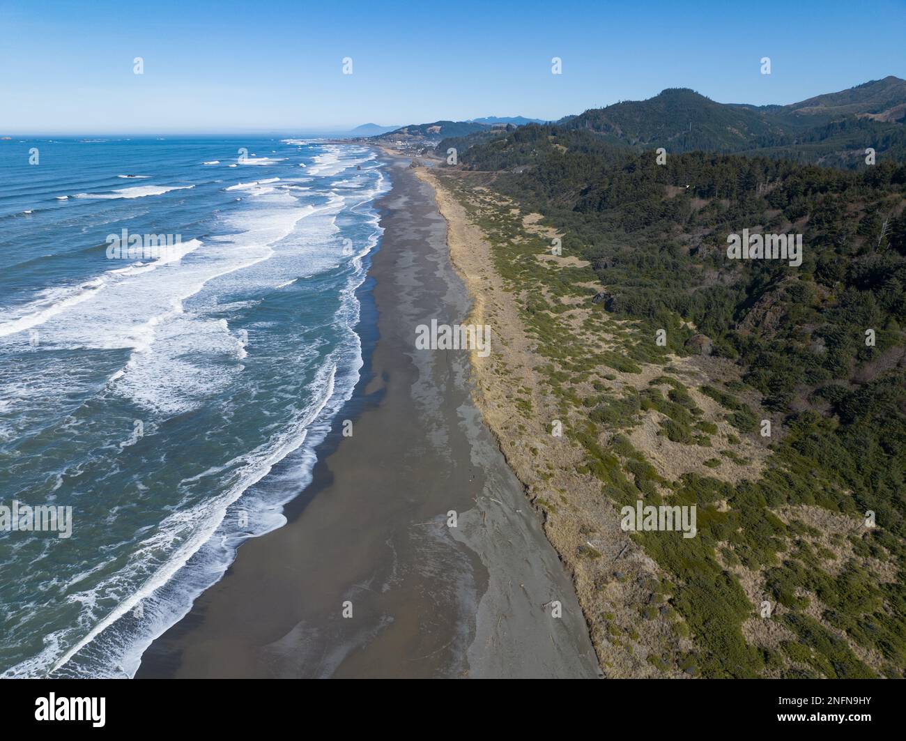La luce del sole del pomeriggio splende sull'Oceano Pacifico e si estende su Gold Beach lungo la panoramica costa meridionale dell'Oregon. Quest'area si trova lungo l'autostrada 101. Foto Stock