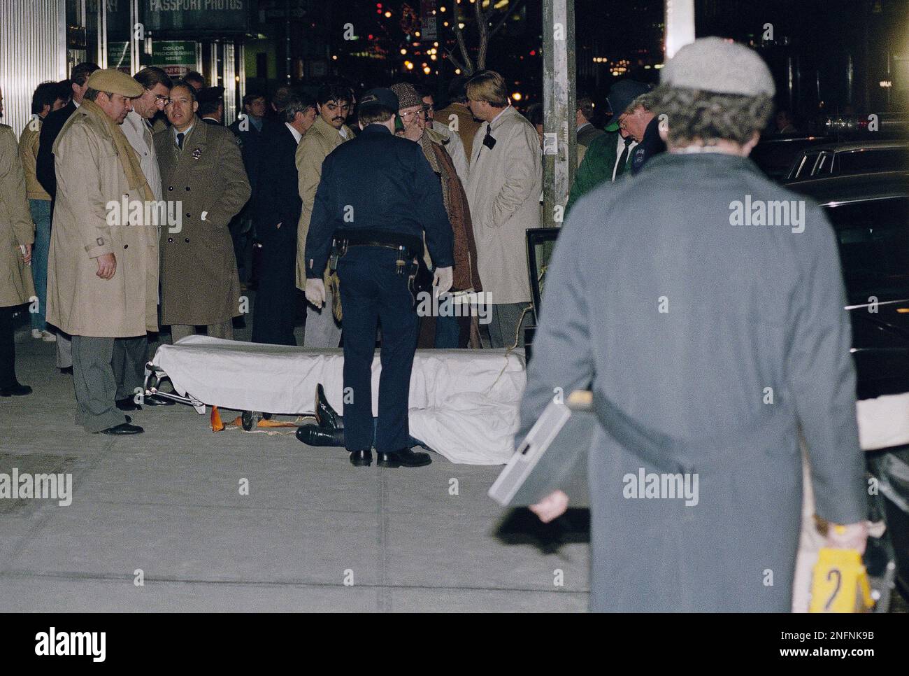 The body of Mafia crime boss Paul Castellano lies on a stretcher outside a New York restaurant after he an his bodyguards were gunned down on Dec. 16, 1985 in New York. Mobster John Gotti claimed the top spot in the Gambino family following the gangland shooting. (AP Photo/Mario Suriani) Foto Stock
