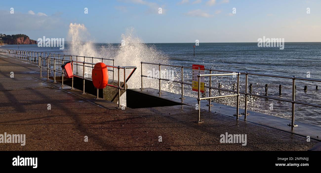 Onde che colpiscono la parete del mare e ringhiere lungo il lungomare a Teignmouth, South Devon. Foto Stock