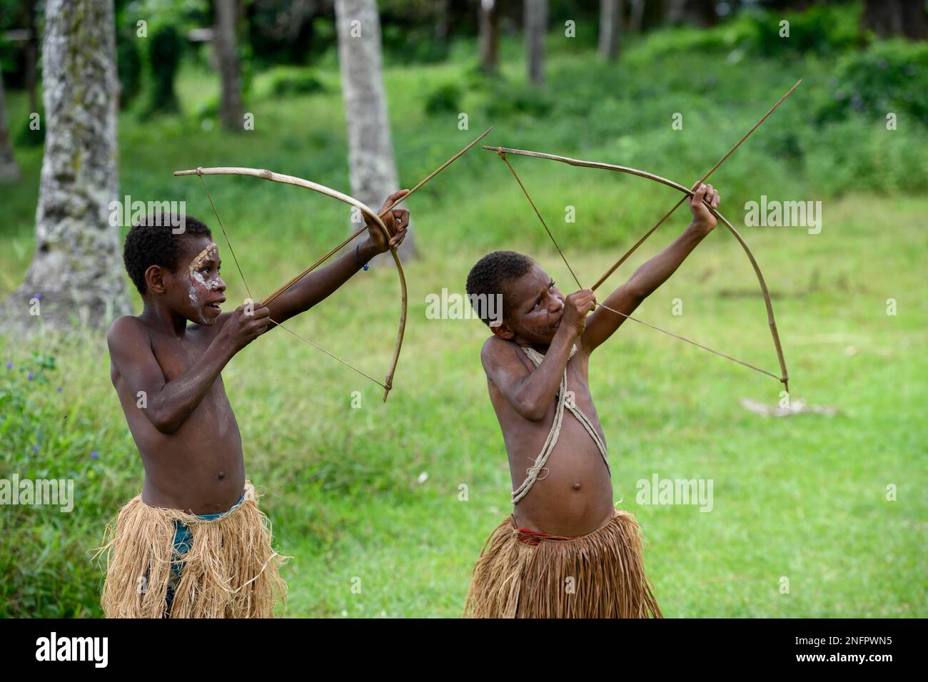 Due ragazzi nativi al tiro con l'arco, villaggio Mutin, Lago Murray, Provincia Occidentale, Papua Nuova Guinea Foto Stock
