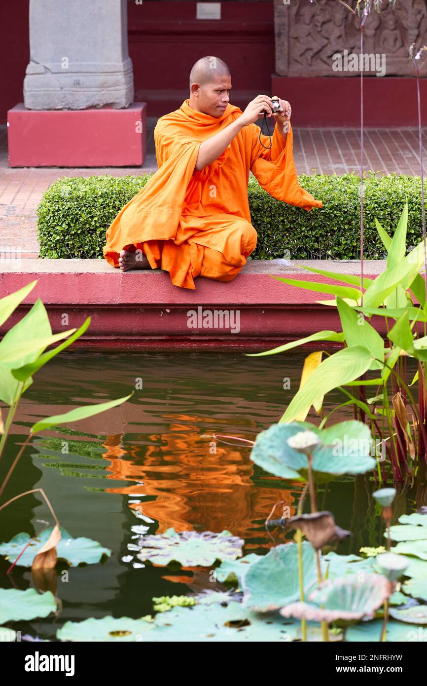 Un monaco buddista scattando una foto al Museo Nazionale Della Cambogia in Phnom Penh Foto Stock