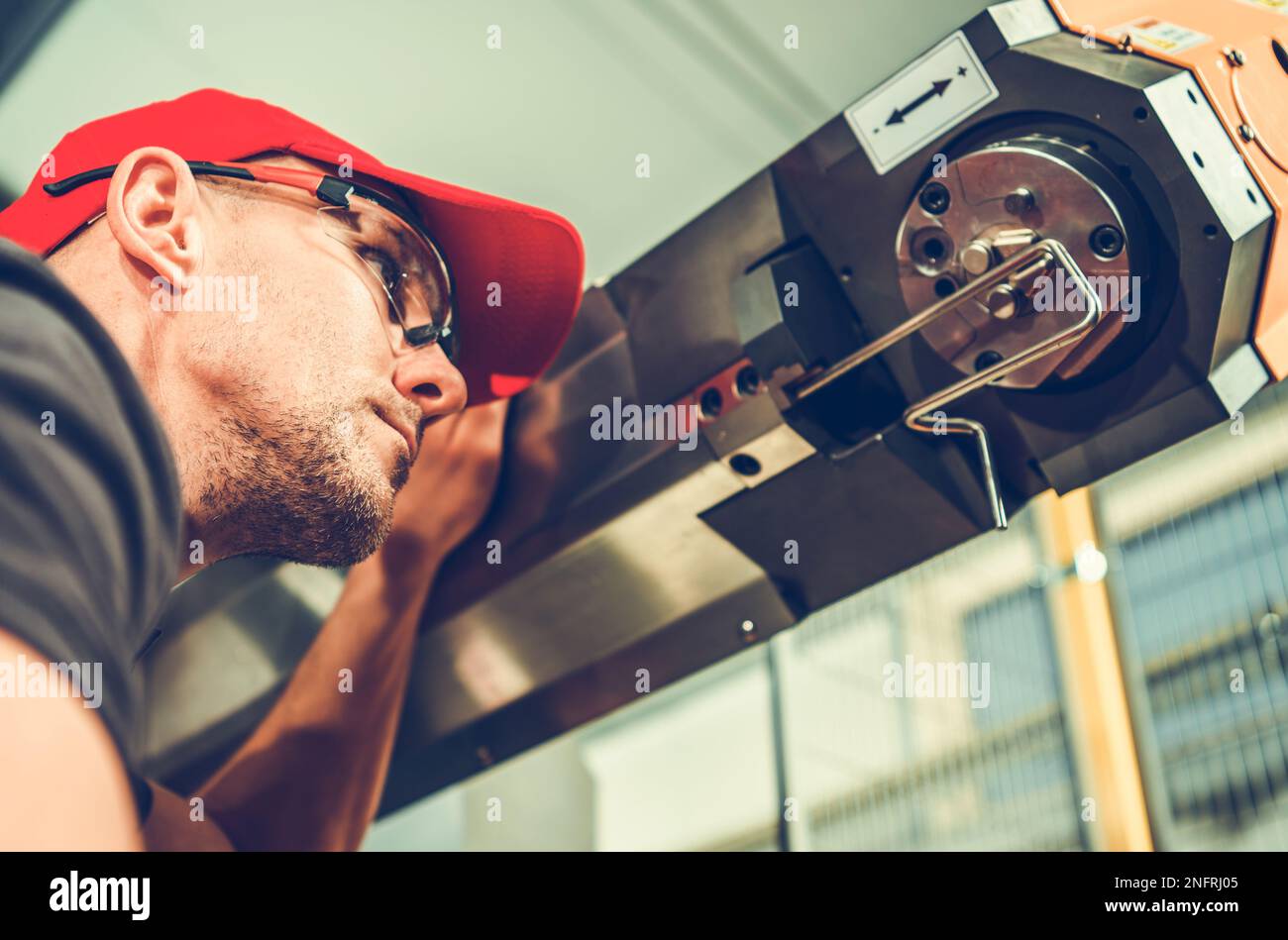 Il funzionamento della piegatrice a filo CNC industriale è controllato da un operatore professionale. Tema tecnologia di produzione. Foto Stock