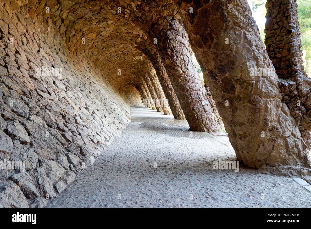 Barcellona. Catalogna. Spagna. Un sentiero colonnato nel Parco Guell, progettato da Antoni Gaudi Foto Stock
