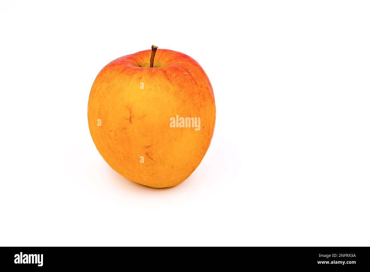 Una mela rosso-arancio come un frutto sano isolato su uno sfondo bianco in studio Foto Stock