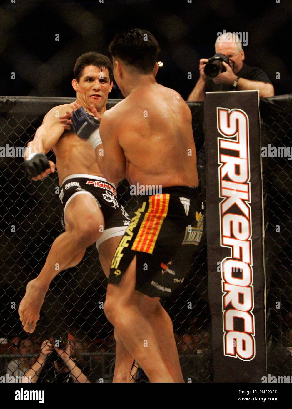 Frank Shamrock, left, kicks Cung Le during their Strikeforce middleweight championship mixed martial arts fight on Saturday, March 29, 2008, in San Jose, Calif. Le won by TKO after Shamrock did not answer the bell to start the fourth round. (AP Photo/Jeff Chiu) Foto Stock