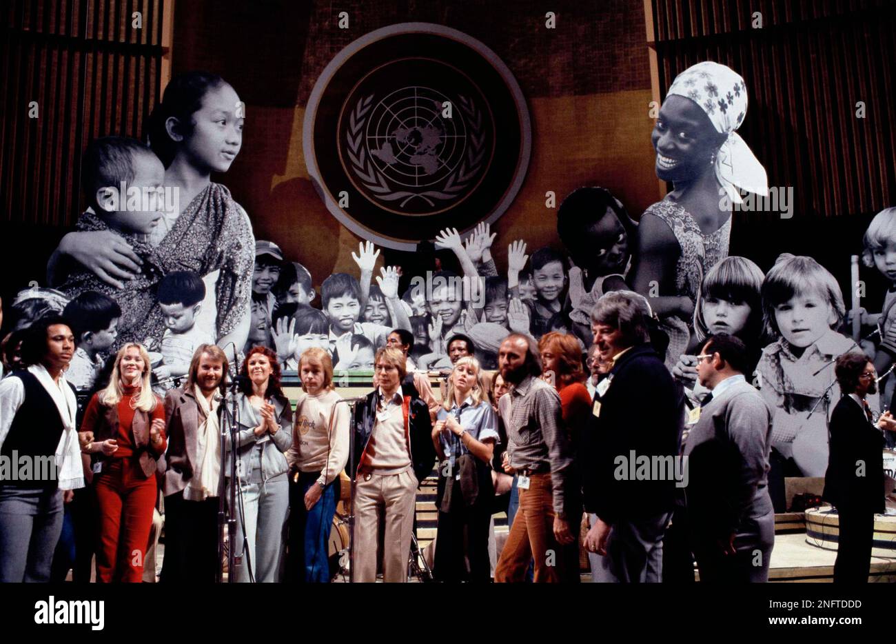 Assembled before giant photo mural are, from left, Rita Coolidge, four members of ABBA, John Denver, Olivia Newton John Gibb, Andy Gibb, of the BEE GEES. They are shown at United Nations General Assembly, Tuesday evening, January 9, 1979 in New York, during taping of NBC-TV Special, "The Music for UNICEF concert." (AP Photo/Ron Frehm) Foto Stock