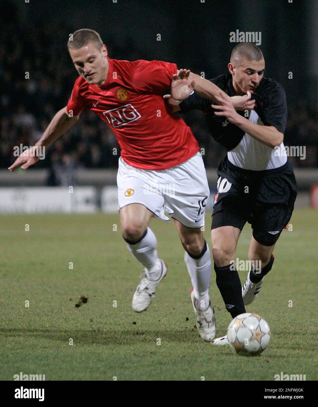 Manchester United defender Nemanja Vidie, left, challenges for the ball with Olympique Lyonnais forward Karim Benzema during their Champions League round of 16 soccer match , Wednesday, Feb. 20, 2008, in Lyon stadium, central France. (AP Photo/Lionel Cironneau) Foto Stock