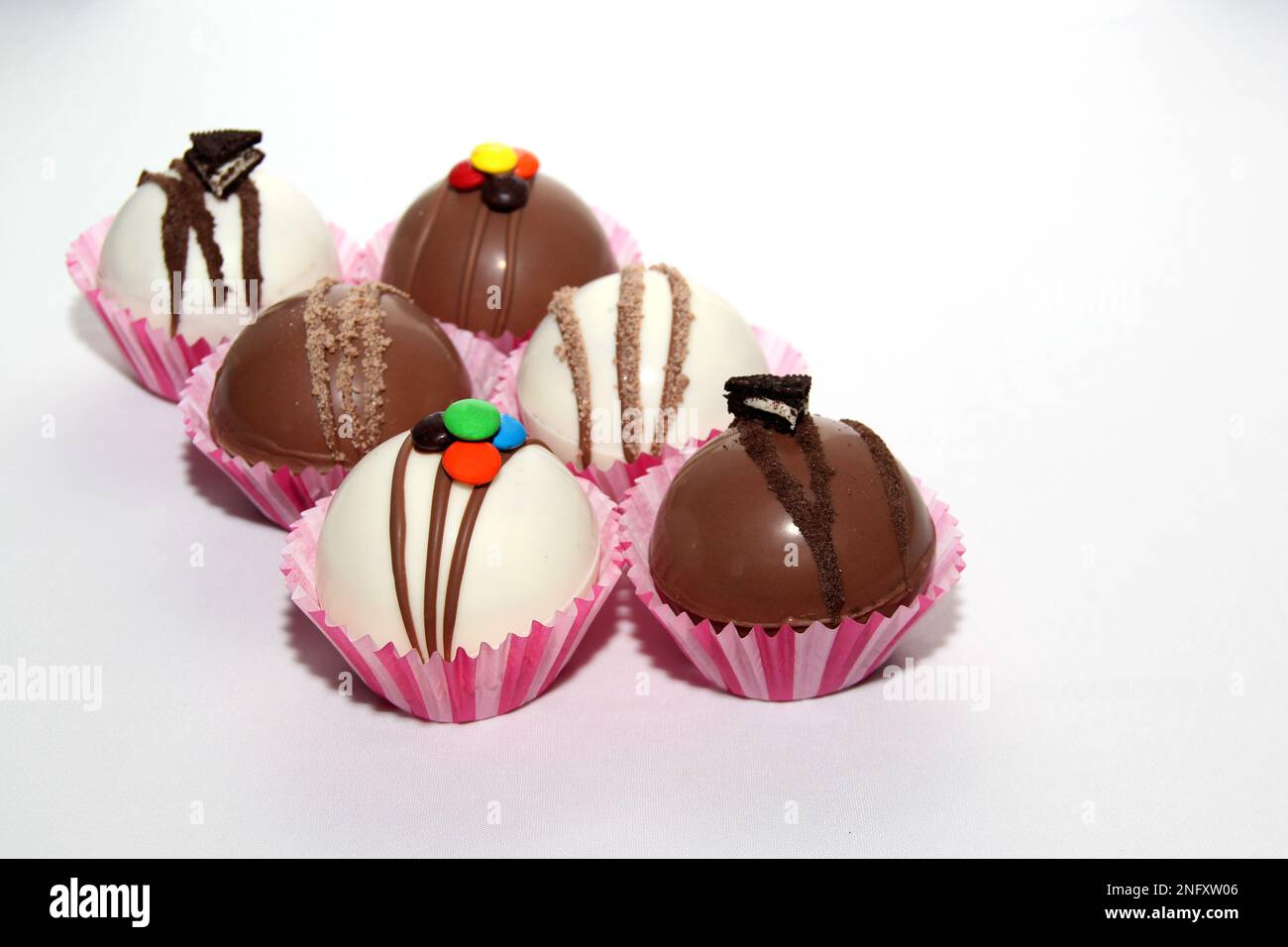 Set di bombe al cioccolato, ripieno di marshmallow e cioccolato bianco su sfondo bianco Foto Stock