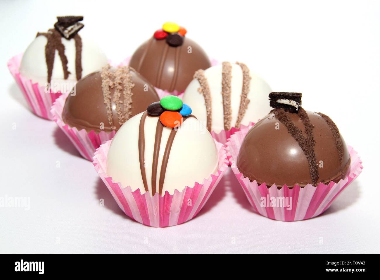 Set di bombe al cioccolato, ripieno di marshmallow e cioccolato bianco su sfondo bianco Foto Stock