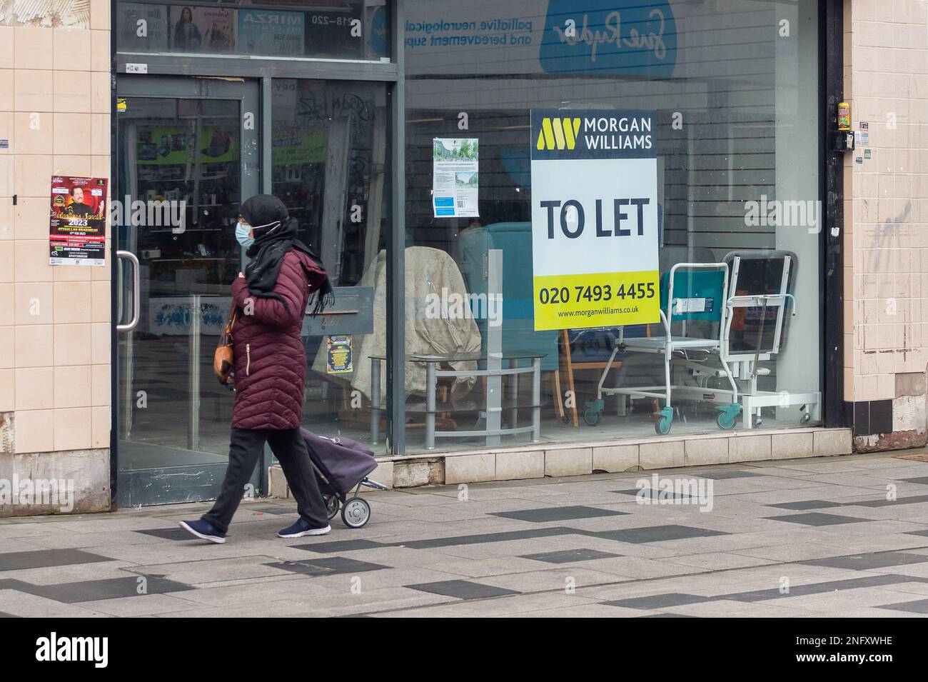 Slough, Berkshire, Regno Unito. 17th febbraio, 2023. Una donna passa davanti a un'unità di vendita al dettaglio vuota. Dopo un calo di due mesi delle vendite al dettaglio, è stato riferito oggi che le vendite al dettaglio sono aumentate nel gennaio 2023, tuttavia, vi è stato un calo complessivo dei volumi delle vendite al dettaglio del 5,7% nei tre mesi fino al mese scorso. Slough High Street era tranquilla oggi come molti proprietari di case stanno lottando per affrontare il costo della crisi e, in particolare, l'alto costo del gas e dell'elettricità. Credit: Maureen McLean/Alamy Live News Foto Stock