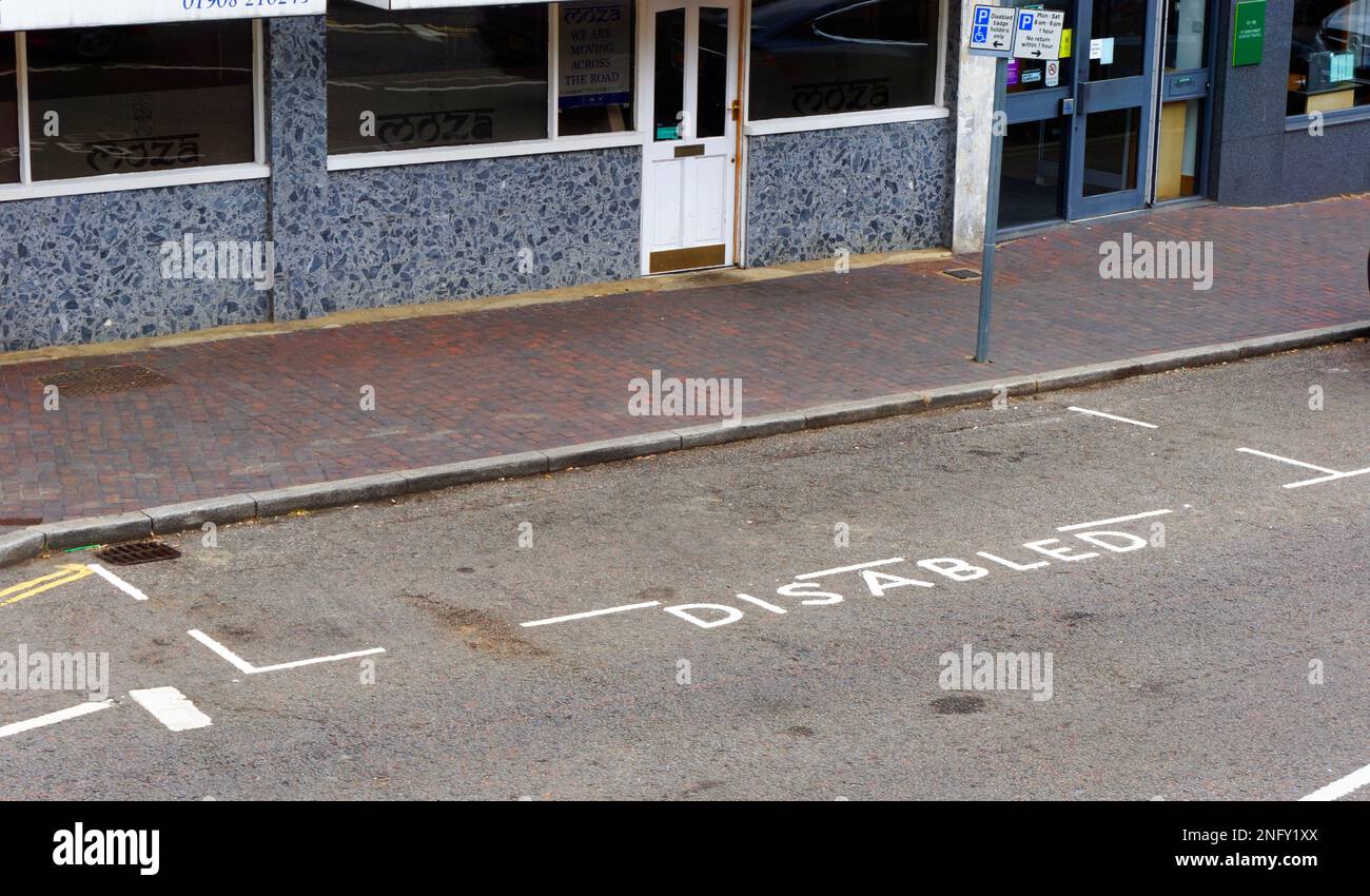 Parcheggio per disabili in una stalla con cartello di parcheggio, vicino ai negozi della città di Newport Pagnell, Bucks. Foto Stock