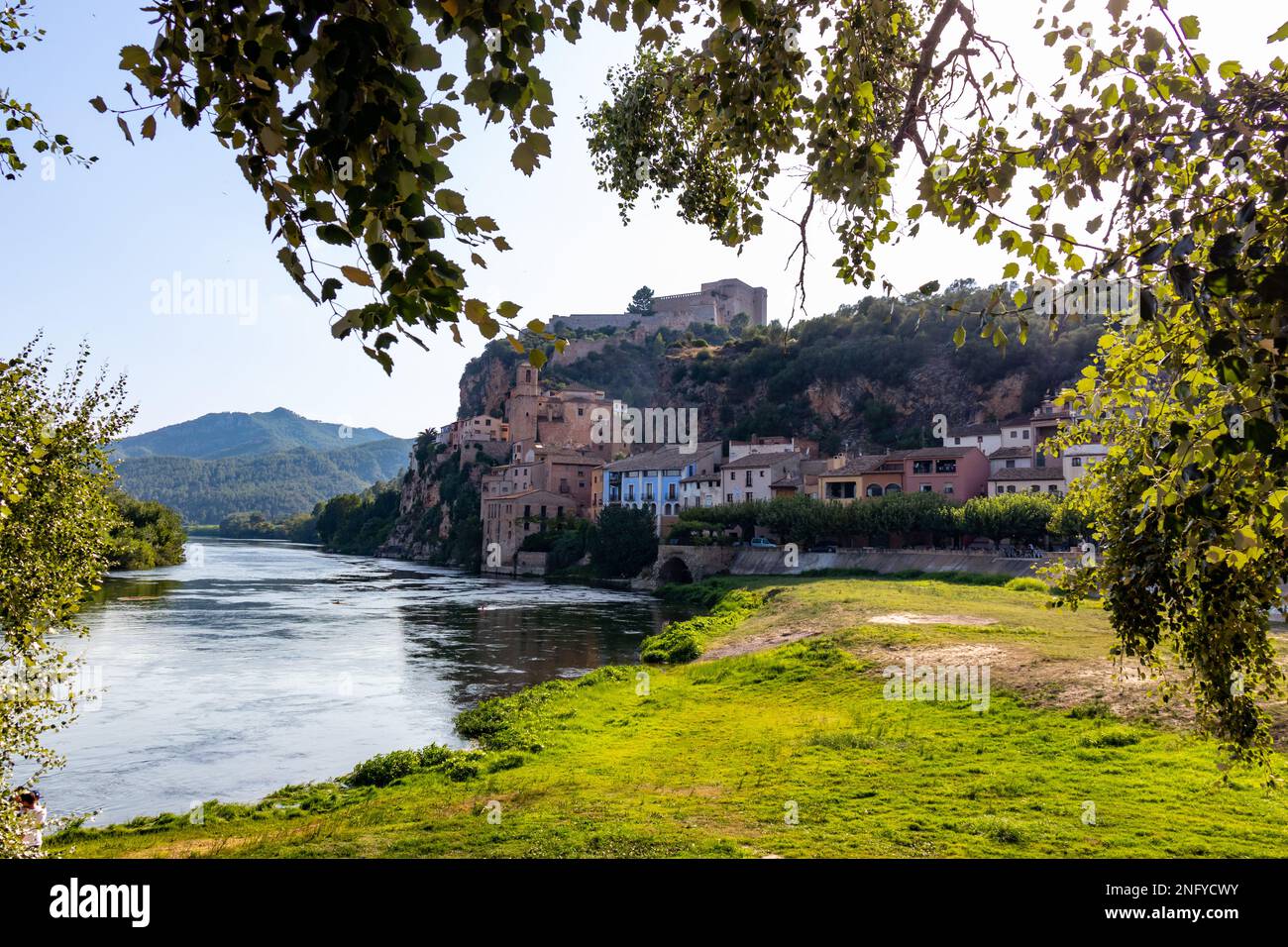 Miravet, uno de los pueblos más bonitos de Tarragona. Se encuentra en un meandro del Río Ebro y aparesce dominado por un impressionante castillo templari Foto Stock