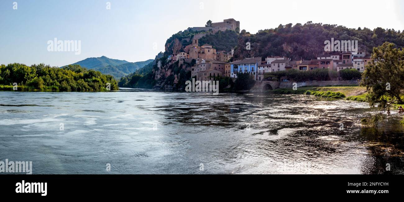 Miravet, uno de los pueblos más bonitos de Tarragona. Se encuentra en un meandro del Río Ebro y aparesce dominado por un impressionante castillo templari Foto Stock