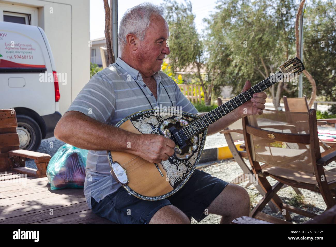 Costas Violaris, proprietario di Agrovino Farm gioca su un bouzouki nel villaggio di Trachoni, nel distretto di Limassol, nel paese isola di Cipro Foto Stock