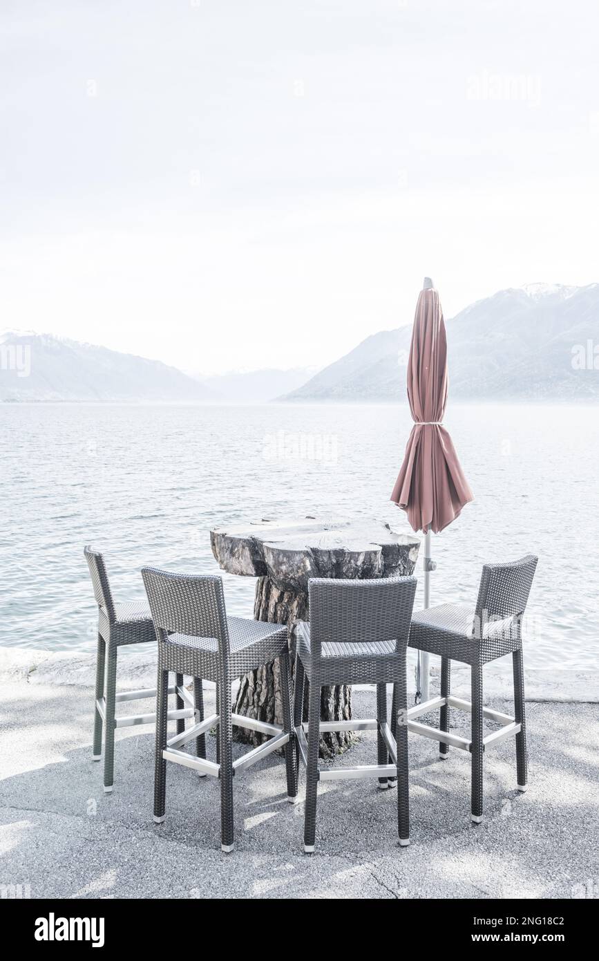 Sedia e tavolo sul lungomare con montagna ad Ascona, Ticino, Svizzera Foto  stock - Alamy