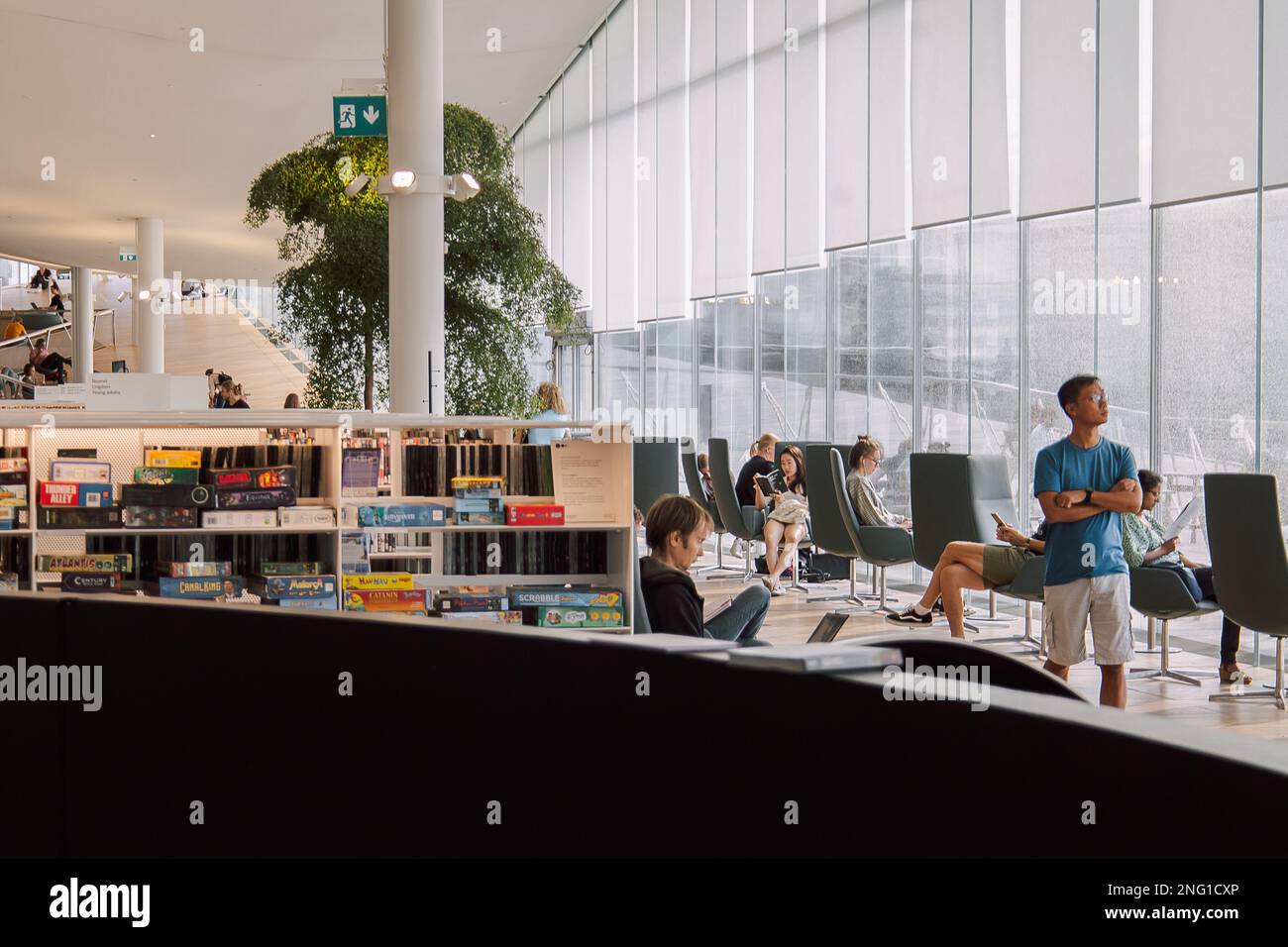 Helsinki, Finlandia - 22 agosto 2022: Biblioteca centrale di Helsinki Oodi. Luogo d'incontro con una gamma di servizi dal design moderno nel centro della città. Le persone leggono libri, lavorano in computer portatili Foto Stock