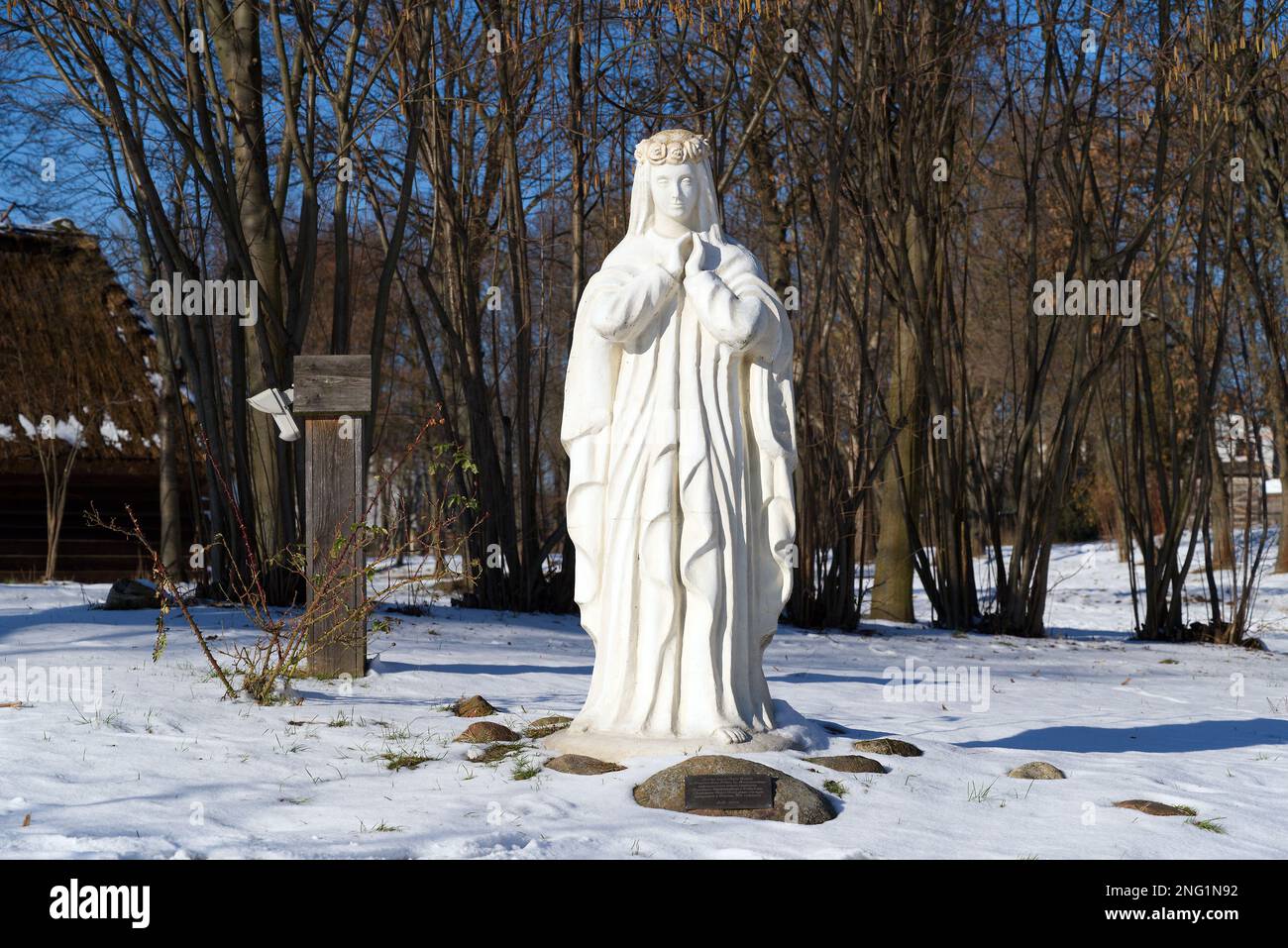 Lublino, Polonia. 08 febbraio 2023. Figura bianca della Vergine Maria nella neve fuori dalla vecchia chiesa in inverno. Foto Stock