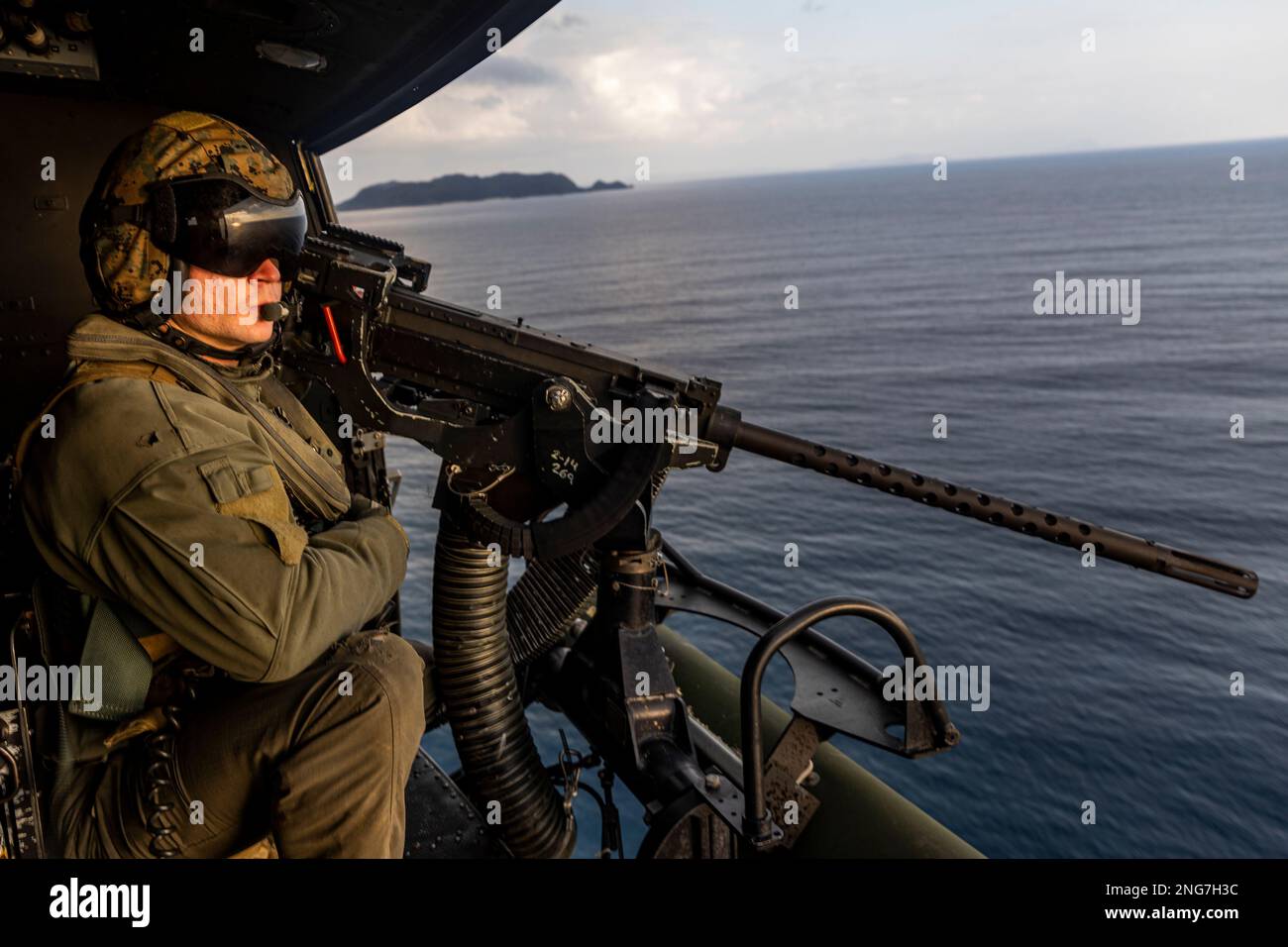 STATI UNITI Bernard McPherson, un capo dell'equipaggio con Marine Light Attack Helicopter Squadron (HMLA) 267, spara una mitragliatrice del calibro di GAU-21 .50 al di fuori di un elicottero UH-1Y Venom durante un evento di addestramento dal vivo a sostegno di Jungle Warfare Exercise (JWX) 23,1 al largo della costa di Okinawa, Giappone, 17 febbraio 2023. JWX 23,1 è un'esercitazione di formazione sul campo su larga scala incentrata sull'utilizzo delle capacità integrate di partner congiunti e alleati per rafforzare la consapevolezza, le manovre e gli incendi in tutti i settori in un ambiente marittimo distribuito. (STATI UNITI Corpo marino foto di Lance CPL. Just Foto Stock