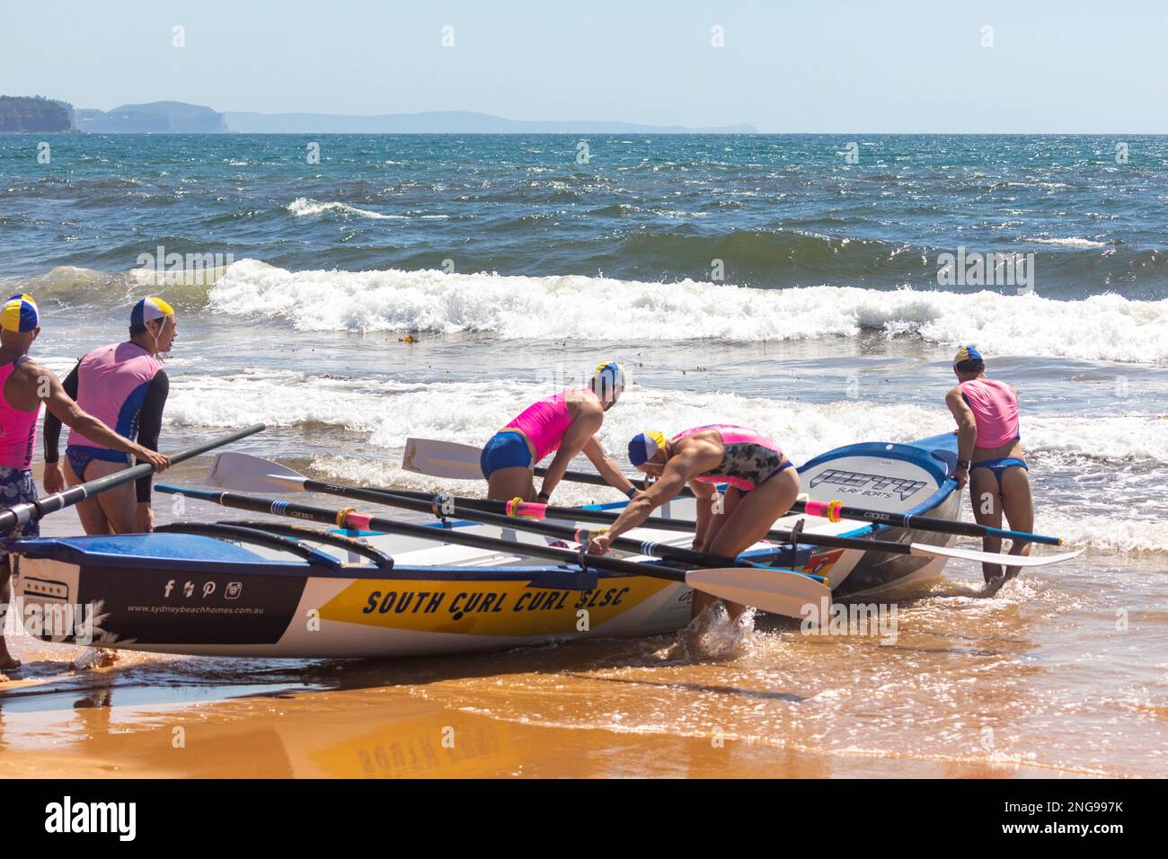 Carnevale australiano di corse di surfboat, squadra di Mens da South Curl Curl SLSC prepararsi a lanciare la loro barca fuori dalla spiaggia di Collaroy a Sydney, NSW, Australia Foto Stock