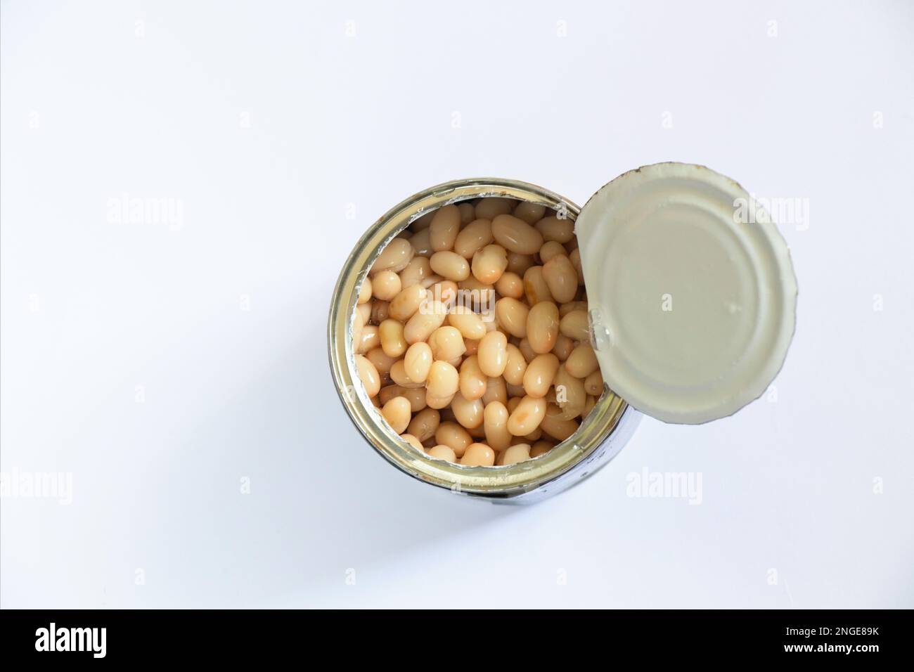 lattina aperta con fagioli in scatola in primo piano con vista dall'alto bianca Foto Stock