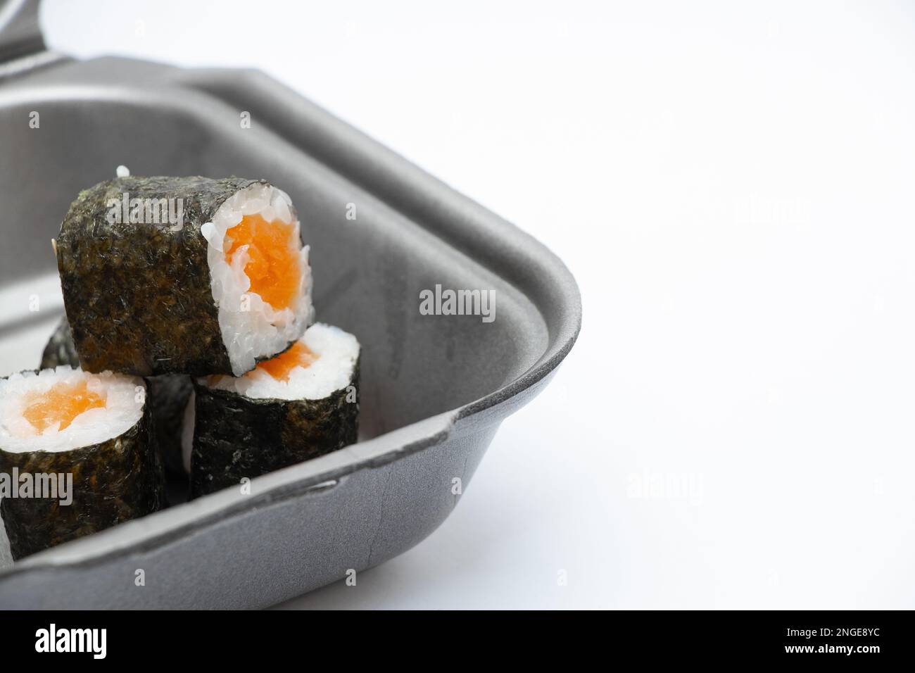 contenitore di plastica con sushi dal ristorante su sfondo isolato, ordine di cibo da asporto Foto Stock
