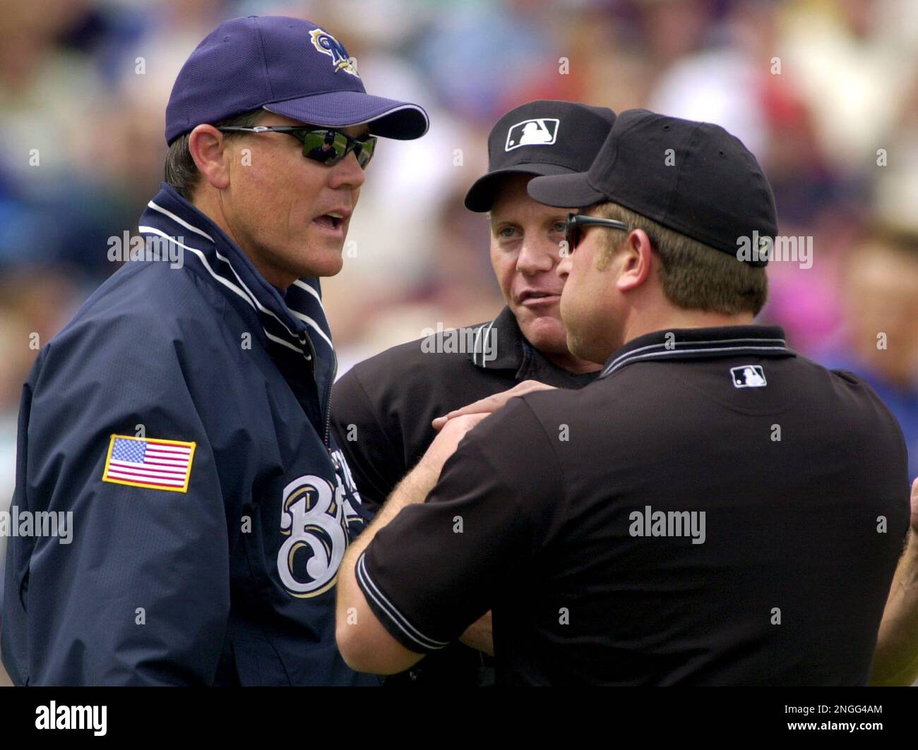 Milwaukee Brewers manager Ned Yost, left, listens as umpires Paul