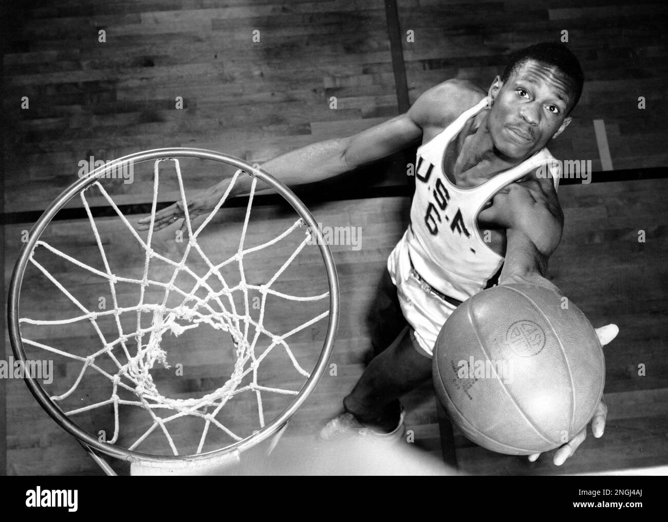 Bill Russell, member of the University of San Francisco basketball team, shows how he scores baskets on Feb. 23, 1956. The 6-foot, 10-inch center, ranked one of the best, has helped his team win 20 straight games during the current season. (AP Photo) Foto Stock