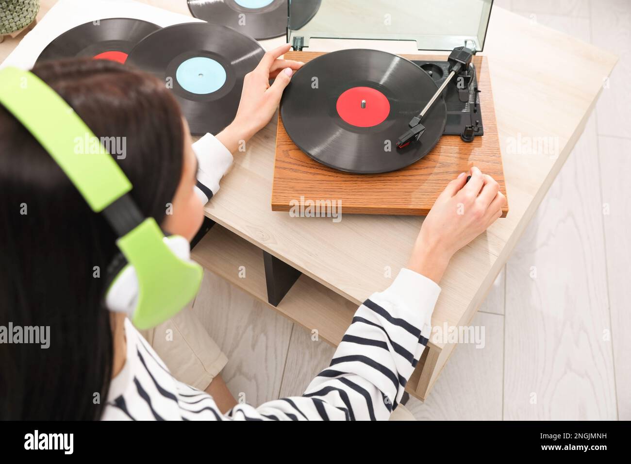Donna che ascolta musica con giradischi a casa, vista dall'alto Foto Stock