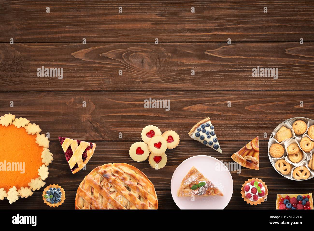 Composizione di posa piatta con diverse torte deliziose su tavola di legno. Spazio per il testo Foto Stock
