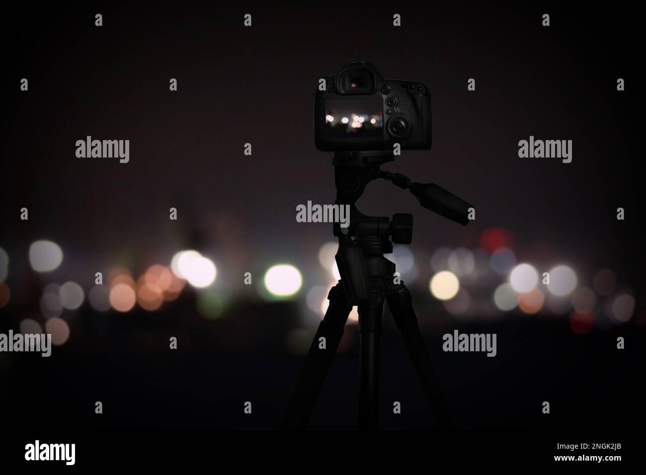 Scattare foto di con la fotocamera montata sul cavalletto. Vista sfocata  delle luci della città di notte, effetto bokeh Foto stock - Alamy