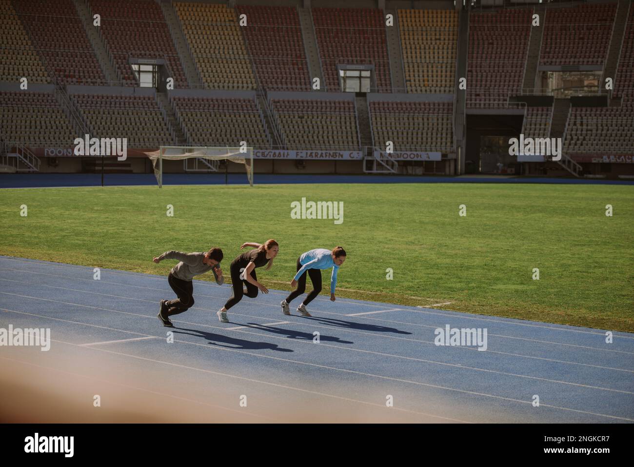 Due femmine e un maschio hanno appena iniziato a sprinting allo stadio Foto Stock