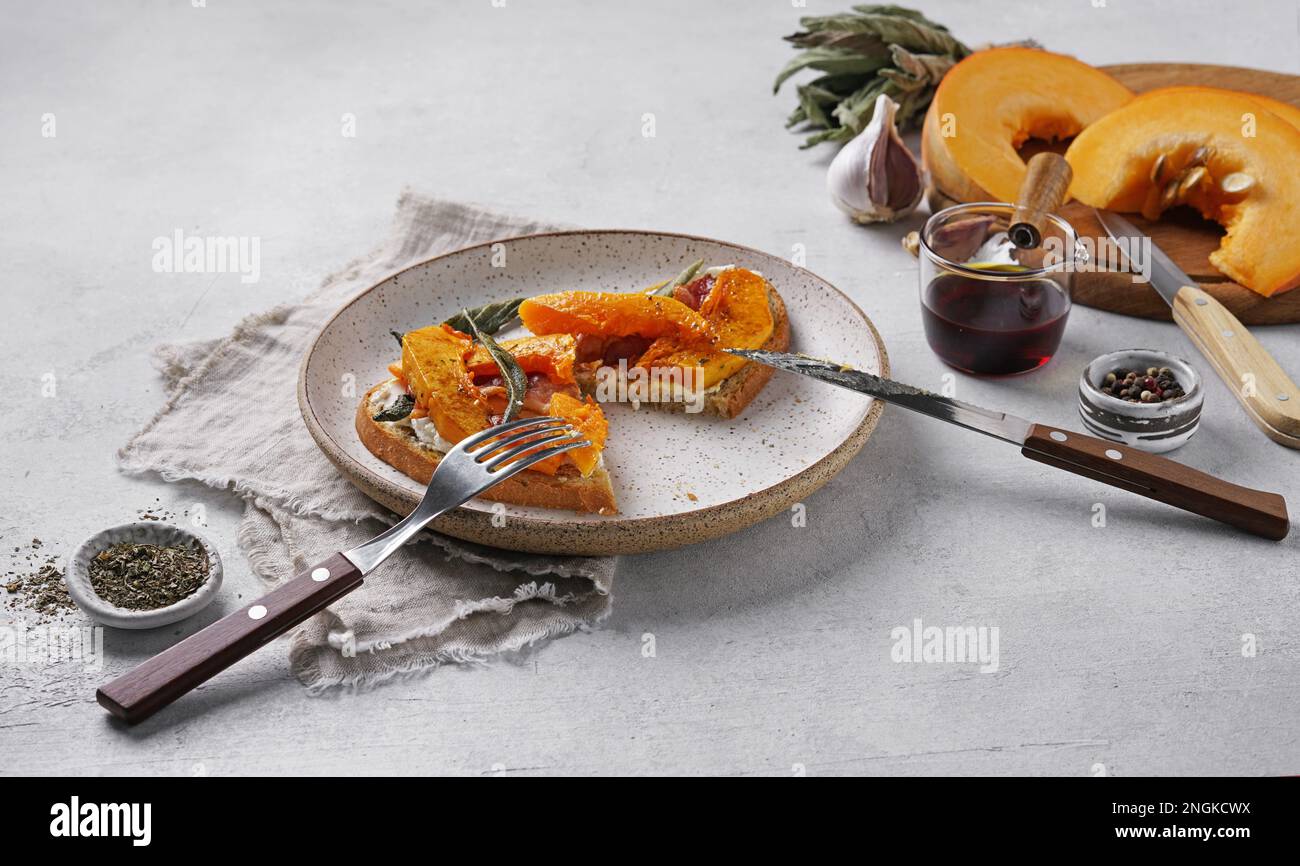 Tagliare la bruschetta con zucca arrosto, pancetta e formaggio e salvia. Messa a fuoco selettiva. concetto breacfast Foto Stock